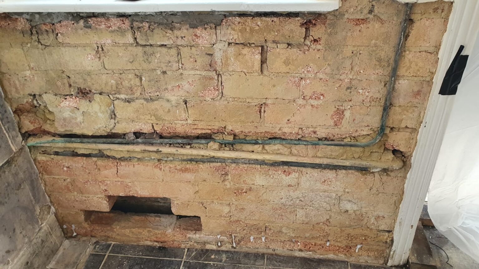 Debris and rubble in cavity wall provides bridge for moisture causing